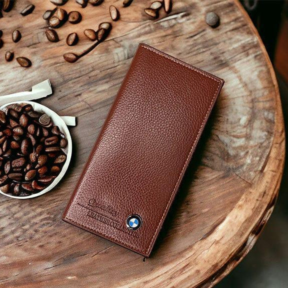 Brown leather wallet on a wooden surface with coffee beans